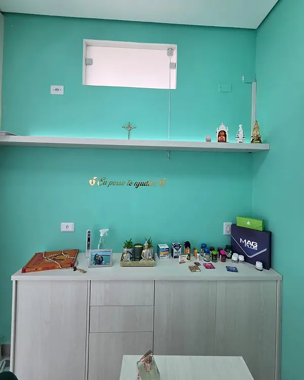 Bancada do consultório com materiais de atendimento e parede verde-água